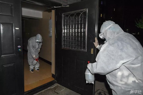 5月10日，在舒兰市一个小区，社区工作人员对楼门进行消毒