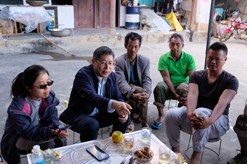 2019年11月，汪三贵教授（左二）一行在云南保山调研贫困户生产与生活情况，与农户围坐讨论咖啡种植收益、易地扶贫搬迁等话题。
