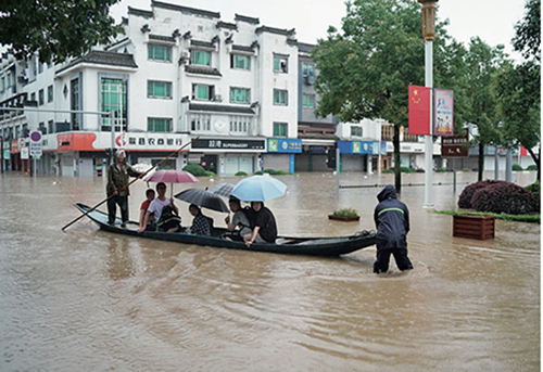 44-2 7月7日，安徽黄山歙县经过一夜的降雨，徽城镇徽州路出现内涝。市民划木船送高考考生前往考场。