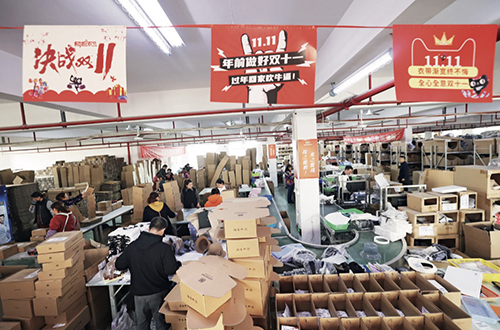 55-1 11 月11 日，在江苏省南通市，电商团队的仓储人员在忙碌地配货打包商品。