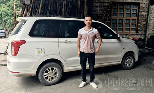 35 王平安在他的新车前。每天早晨他都会驾驶着这辆车去摆地摊，这是他人生中拥有的第一台一手车。