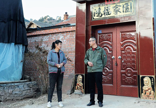 96 山西省沁源县扶贫干部王晓飞（右）在村民田灵珍家门口大棚指导香菇种植技术