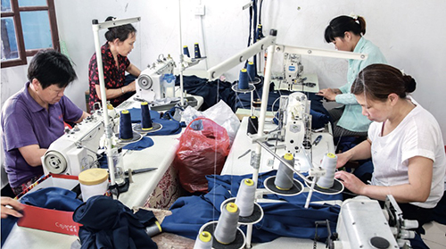 94 在徐结红夫妻俩经营的服装工厂，工人们正在忙碌地加工服装。