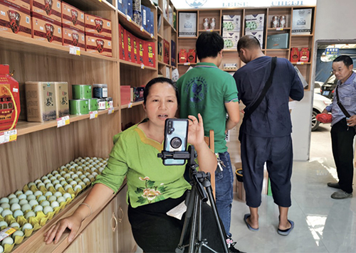 80 “香橙妈妈大学”项目学员杨帆（左一）在店铺里做直播销售雷山“绿皮鸡蛋”