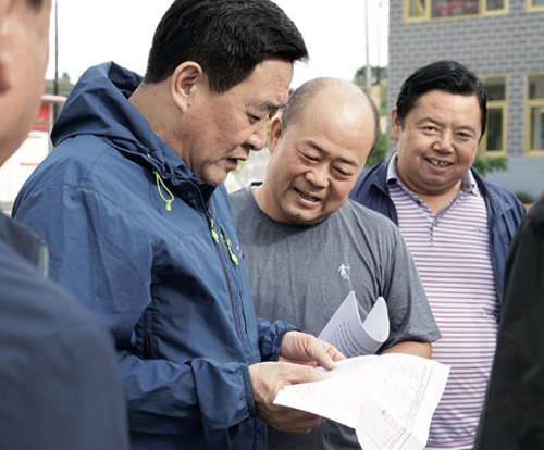 75-1 在扶贫点，金川集团党委书记、董事长王永前（左）听取驻村干部工作汇报