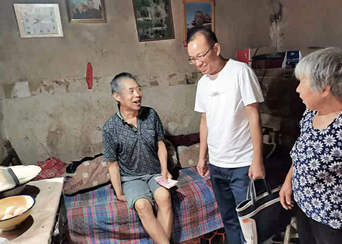71 中国诚通派驻沙坡村第一书记吴五华（左二）慰问贫困户