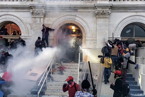 96 当地时间2021 年1 月6 日，美国华盛顿特区，抗议者试图强行进入国会大厦，警察扔催泪瓦斯赶