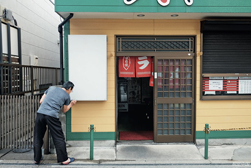 99 日本神奈川县，一名工人准备关闭一家拉面店。