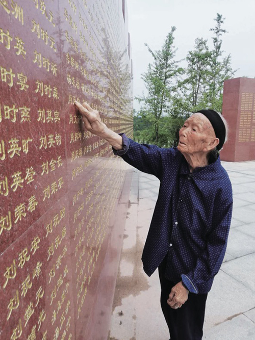17 103 岁高龄的段桂秀是赣州地区唯一还健在的红军烈士遗孀，在烈士纪念碑前寻找丈夫王金长的名字。