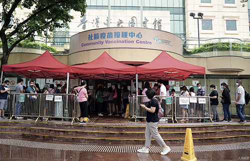 82 5 月29 日下午，众多市民在位于香港中央图书馆的社区疫苗接种中心门口排队等候接种新冠疫苗。