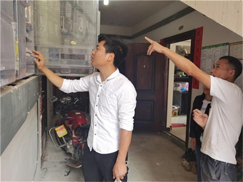 图3：黎绪在为社区居民检修电表