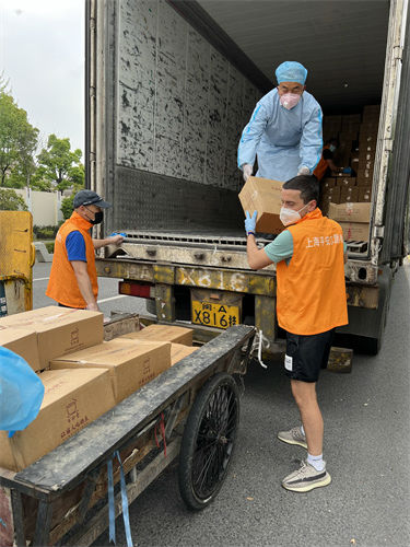 宋文龙（右一）和物业、志愿者们一起卸货