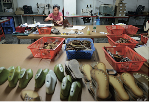 18东莞市一位鞋厂的女工正在加紧生产。越南的人工成本比东莞低。